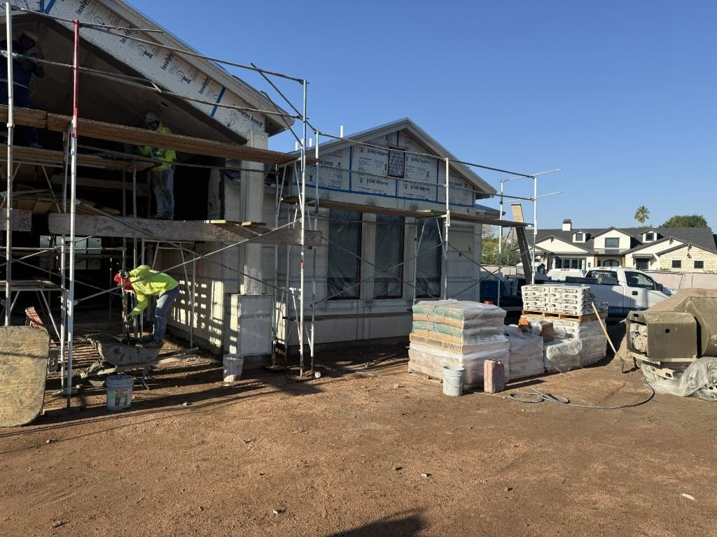 Stucco crew applying an exterior system from scaffolding