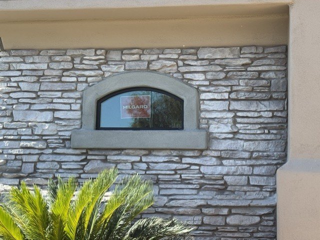 Decorative stone accents surrounding an arched exterior window